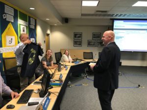 Tom Doppe, former AHS principal, presents a shirt to his newly hired successor, Matt Chamberlain