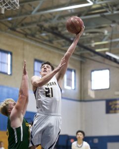 Brody Eglite soars to the basket as Capuchino's Kenny Osterfund defends