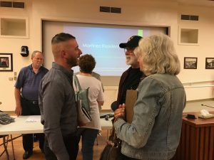 Brandon Varise (left foreground) speaks with two Martinez residents.